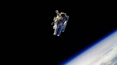 L’astronaute R. Stewart en impesanteur dans l'espace, avec la Terre en arrière-plan