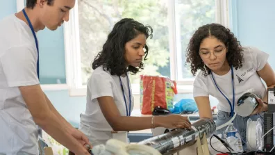 Trois jeunes membres assemblent une fusée expérimentale Trois jeunes membres assemblent une fusée expérimentale