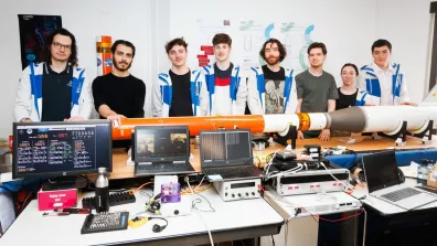 Des étudiants posant avec une maquette de mini-fusée Des étudiants posant avec une maquette de mini-fusée