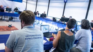 Un groupe de personnes assises à des tables lors d'une conférence Un groupe de personnes assises à des tables lors d'une conférence