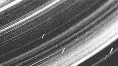 Photo prise par la sonde Voyager 2 des anneaux d’Uranus. Les petits traits verticaux que l’on peut voir sont des particules de poussière.  Photo prise par la sonde Voyager 2 des anneaux d’Uranus. Les petits traits verticaux que l’on peut voir sont des particules de poussière.