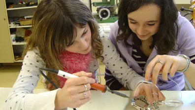 Deux jeunes filles en train d'assembler un capteur  Deux jeunes filles en train d'assembler un capteur