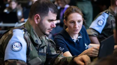 Une ingénieure du CNES coopère avec un militaire pendant l'exercice AsterX, en 2024.