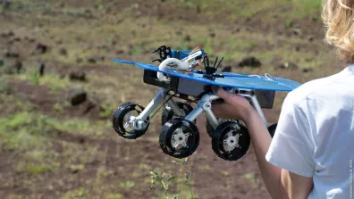 Un enfant tient un rover martien miniature Un enfant tient un rover martien miniature