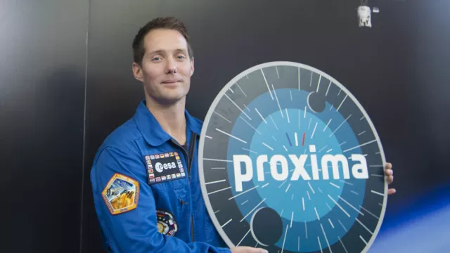 Photographie de Thomas Pesquet posant avec le logo de la mission Proxima Photographie de Thomas Pesquet posant avec le logo de la mission Proxima