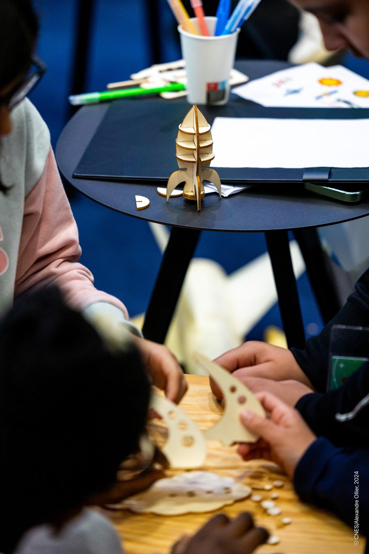 Enfants assemblant une fusée en carton lors de l'opération Rêves de gosse Enfants assemblant une fusée en carton lors de l'opération Rêves de gosse